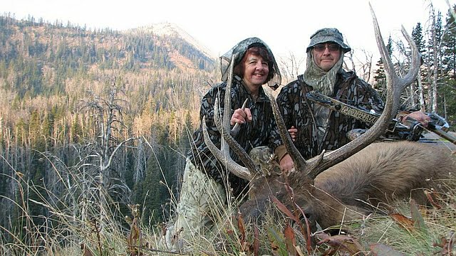 Happy hunting man and wife with elk